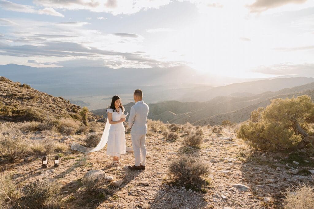 Golden hour sunset vows with epic desert views during Joshua Tree elopement at Keys View Couple exchanging vows during golden hour sunset at Keys View with sweeping desert mountain views while eloping in Joshua Tree.