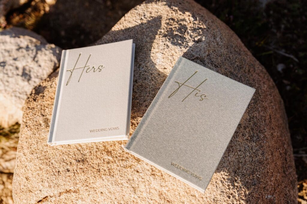 Elopement vow books captured in Joshua Tree desert setting His and Hers vow books resting on desert rocks during an intimate Joshua Tree elopement.