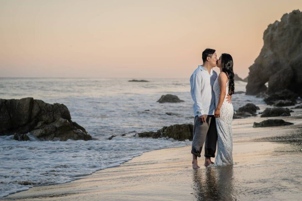 Couple kissing on the shoreline at El Matador State Beach during their Malibu elopement