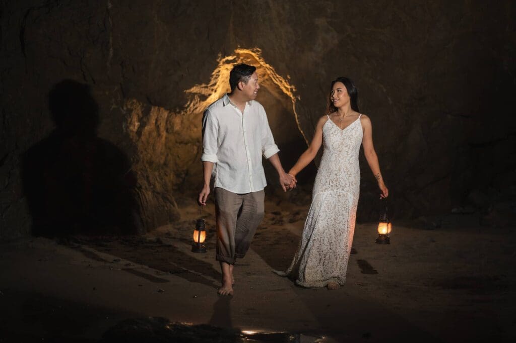 Bride and groom walking barefoot through a sea cave at El Matador State Beach during their intimate Malibu elopement