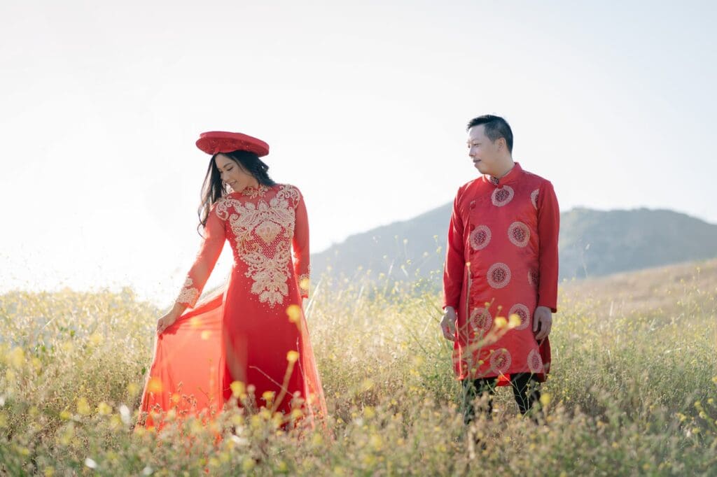 Bride and groom wearing red Vietnamese Ao Dai in a wildflower field at Malibu State Park during their Malibu elopement