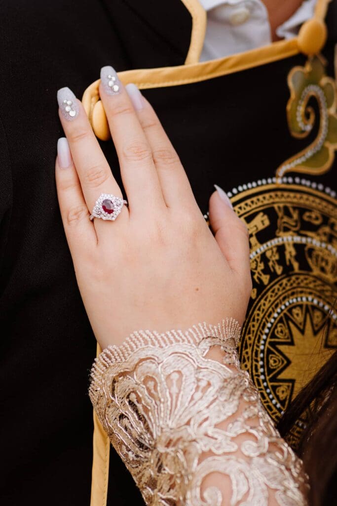 Detailed shot of Vietnamese Ao Dai lace cuff and ruby engagement ring during an intimate wedding at Joshua Tree
