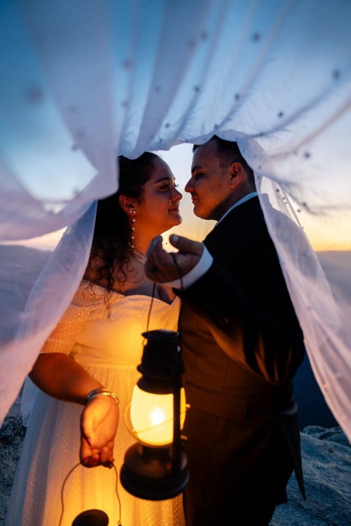 Romantic under-the-veil moment at sunset with lantern glow